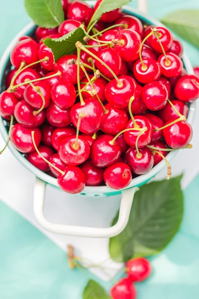 Fresh red cherry fruit green colander — Stock Photo, Image