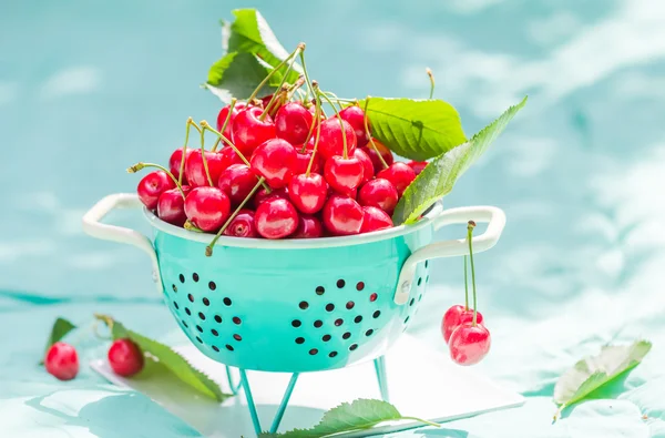 Fresh red cherry fruit green colander — Stock Photo, Image