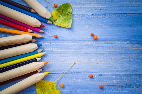 Vintage baggrundsfarvede blyanter efteråret frugter blå bord - Stock-foto