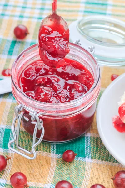 Scooping gooseberry jam jar spoon — Stock Photo, Image