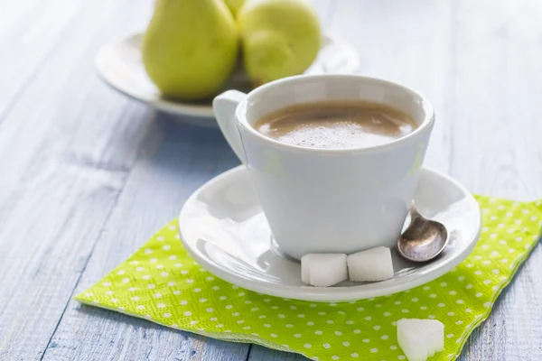 Kaffeetasse schwarze Holzplatte braune Birnen weiße Kanne Milch — Stockfoto