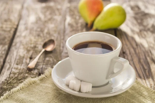 Kawy kubek czarny brązowy deska drewniany gruszki biały — Zdjęcie stockowe