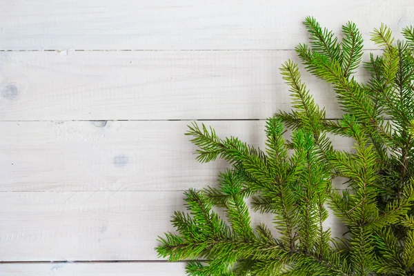 Vánoční pozadí zelení smrkových větviček bílé dřevěné — Stock fotografie