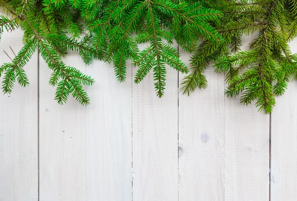 Natal fundo greens abeto galhos branco de madeira — Fotografia de Stock
