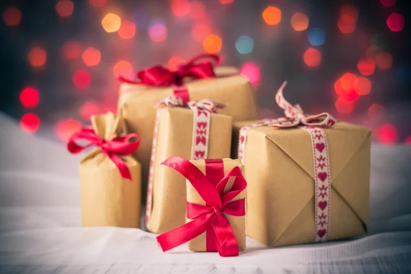 Csomagok bemutatja karácsonyi háttér színes fények ajándék — Stock Fotó