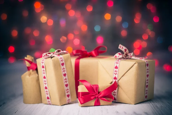 Paket presenterar bakgrunden färgade lampor julklapp — Stockfoto