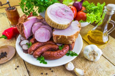 çeşitli türlü sosis çevrili yeşil plaka