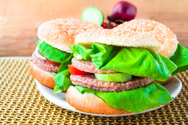 Dřevěná rohož dva domácí grilovaný hamburger — Stock fotografie