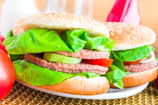 Två hemgjorda grillade hamburgare trä matta — Stockfoto