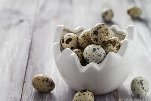 Pequeños huevos de codorniz plato de mesa de madera — Foto de Stock