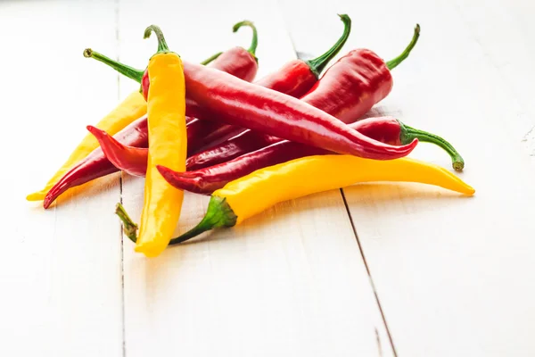 Rote gelbe Chilischoten hölzernen Hintergrund — Stockfoto