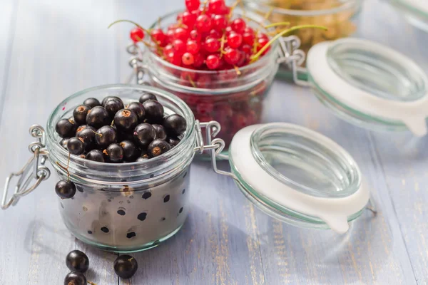 Kleurrijke bessen vruchten potten houten tafel — Stockfoto