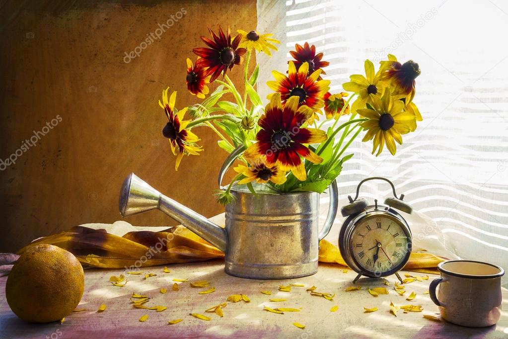 Still life with bouquet yellow rudbeckia watering can clock