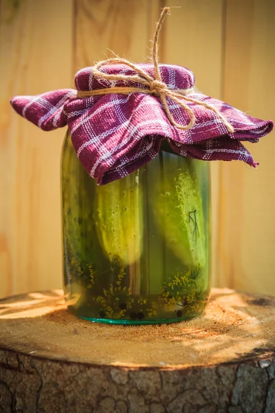 Jar pepinos en vinagre tocón de madera — Foto de Stock