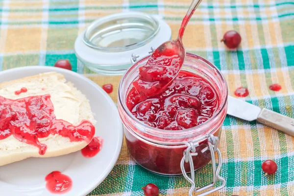Scooping gooseberry jam jar spoon — Stock Photo, Image