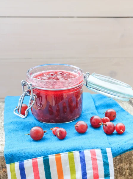 Piccolo vaso di uva spina marmellata tessuto blu — Foto Stock