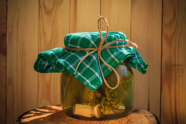 Jar pickled cucumbers wooden stump — Stock Photo, Image