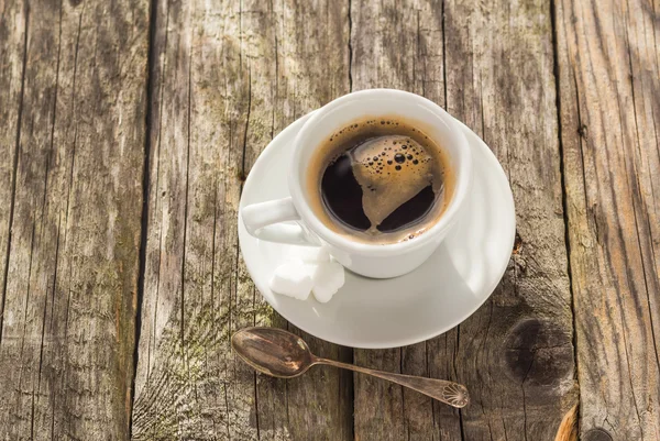 Taza de café negro tablero de madera marrón blanco — Foto de Stock