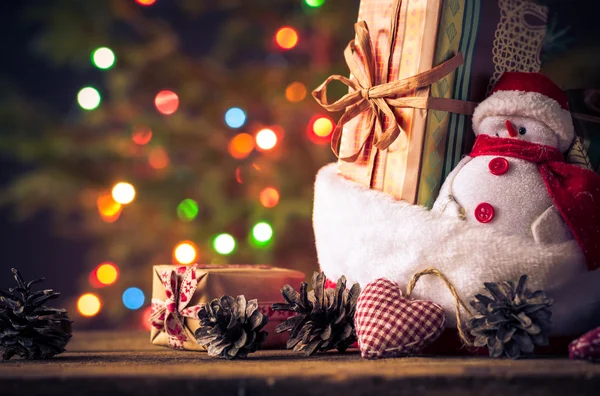 Χριστουγεννιάτικη κάρτα χιονάνθρωπος στολίδια δώρα δέντρο φώτα φόντο — Φωτογραφία Αρχείου
