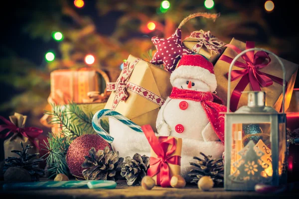 Kerstkaart-Sneeuwman ornamenten geschenken boom lichten achtergrond — Stockfoto
