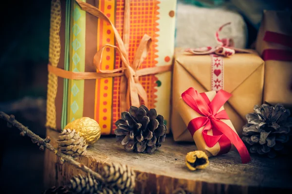 Papai Noel presentes de Natal pacotes cones mesa de madeira — Fotografia de Stock