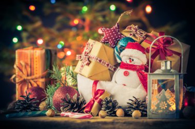 Noel kartı kardan adam hediyeler ağacı ışıkları arka plan süsler