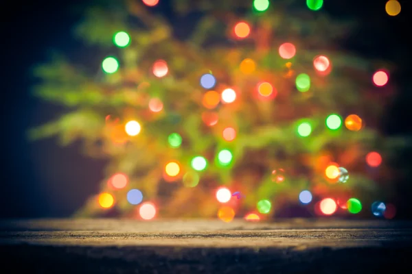 Feestelijke achtergrond houten tafel kerstboom lichten — Stockfoto