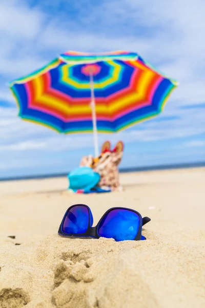 Occhiali da sole blu sfondo ombrello — Foto Stock