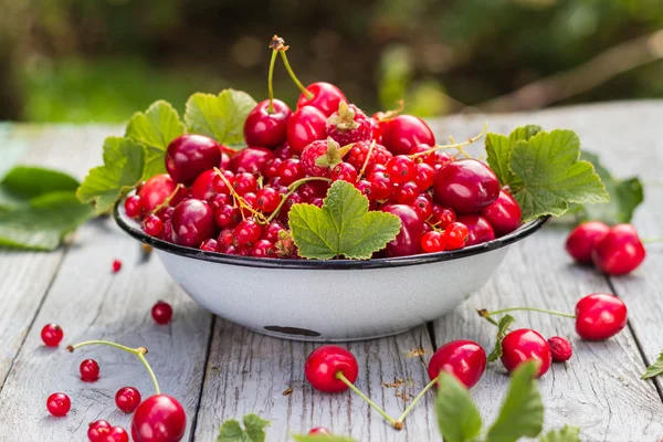 Schale voller verschiedene Früchte hölzernen Hintergrund — Stockfoto