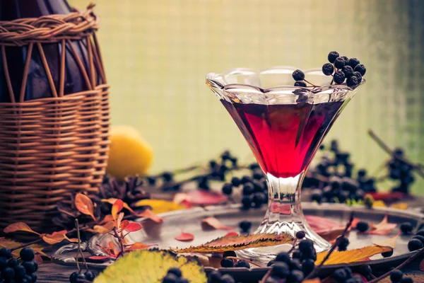 Glass tincture chokeberry autumn vintage styling — Stock Photo, Image