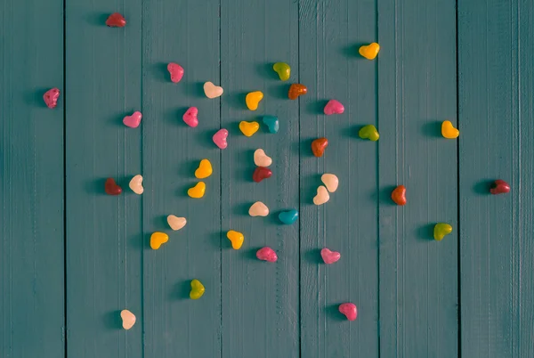 Many colorful little hearts wooden background — Stock Photo, Image