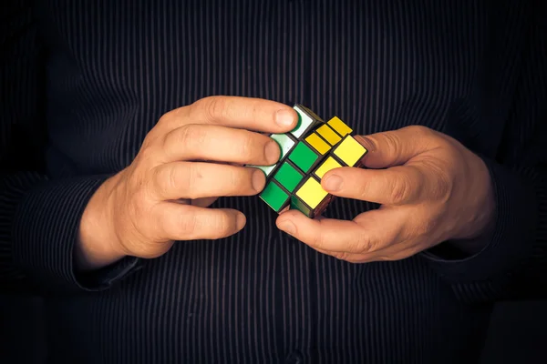 Man probeert oplossen Rubik kubus — Stockfoto