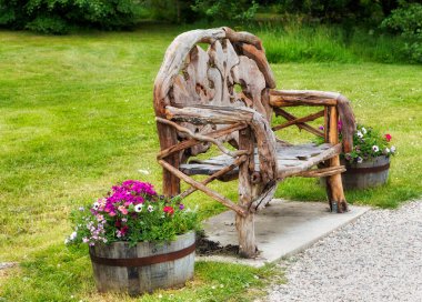 Bahar parkındaki ahşap bank ve renkli çiçekler.