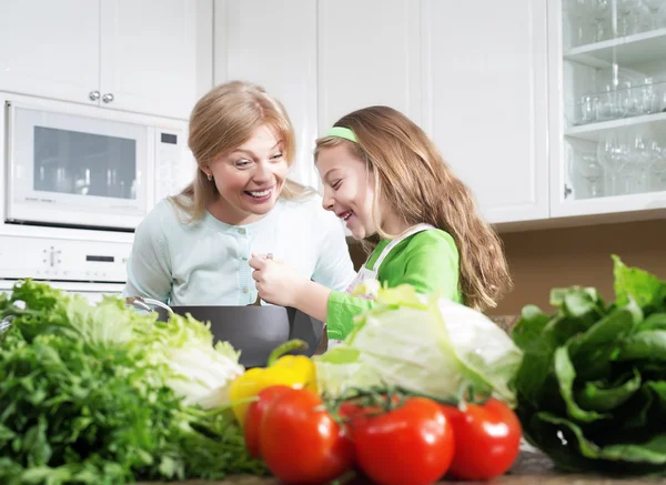 Vista de menina bonita jovem cozinhar na cozinha com sua mãe — Fotografia de Stock