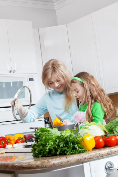 Vista della giovane bella ragazza che cucina in cucina con la sua mamma — Foto Stock