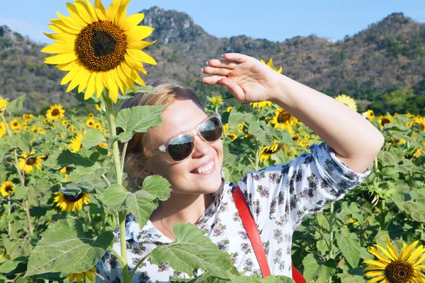 Portret van jonge lachende gelukkige vrouw doordringt de zonnebloem veld — Stockfoto