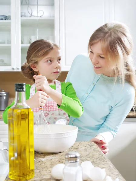 View of young beautiful girl cooking at the kitchen with her mama — Stock Photo, Image