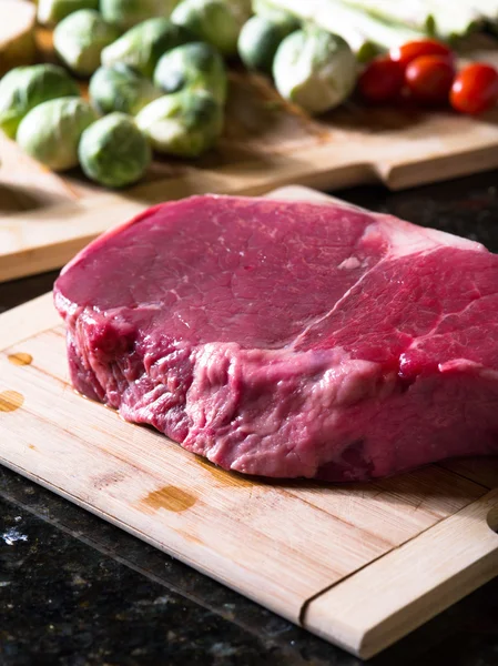 Zbliżenie świeży kawałek mięsa z niektórych warzyw na plecach — Zdjęcie stockowe