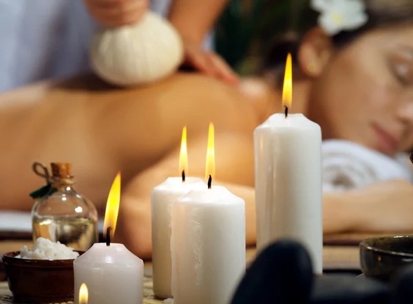 Porträt einer jungen schönen Frau, die sich in der Wellness-Umgebung entspannt. Kerzenschein im Mittelpunkt. — Stockfoto