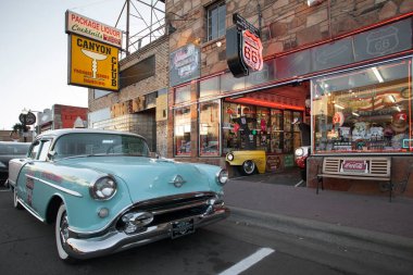 Williams, Arizona, USA: May 2014: Street scene with classic car in front of souvenir shops in Williams, one of the cities on the famous route 66 clipart