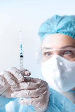 Doktorun mavi sırtında bir şırınga şırıngası olan görüntüsünü kapat.