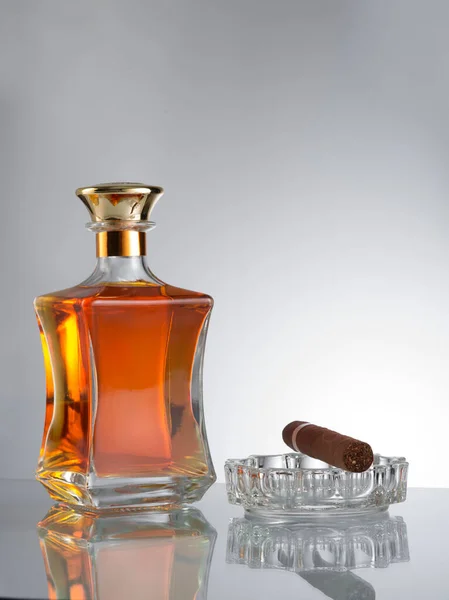 Close Zicht Sigaar Fles Cognac Een Glas Opzij Grijze Rug — Stockfoto