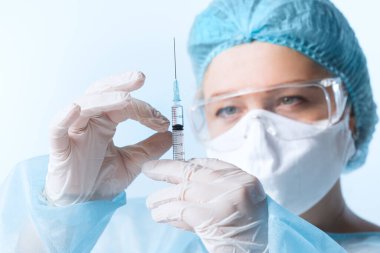 Doktorun mavi sırtında bir şırınga şırıngası olan görüntüsünü kapat.