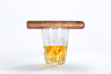 Kapalı bir viski bardağı manzarası ve beyaz sırtında puro.