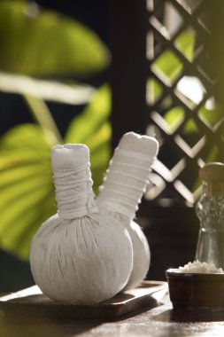 close up view of salt, oil and Herbal massage Compress on green back. 