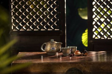 Güzel porselen çaydanlığın ve renkli bardakların yakın görüntüsü.