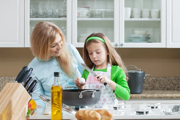 View of young beautiful girl cooking at the kitchen with her mama — Stock Photo, Image