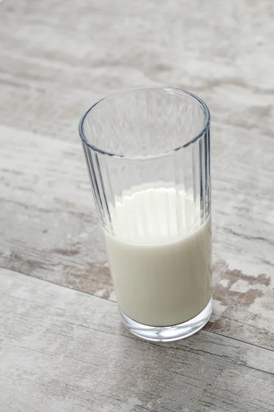 Primer plano vista de vidrio lleno de leche fresca sobre tabla de maderaprimer plano vista de vidrio lleno de leche fresca sobre mesa de madera —  Fotos de Stock