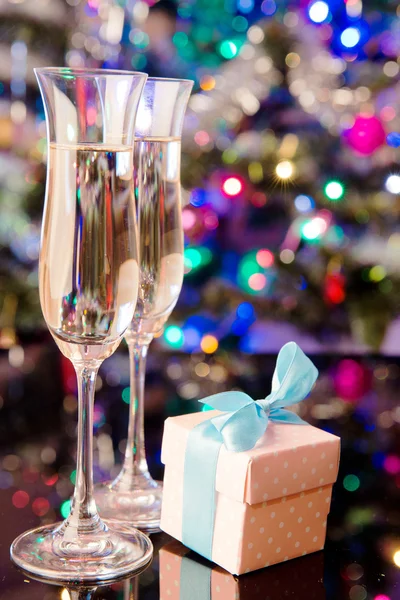 Two glasses of champagne and a gift — Stock Photo, Image