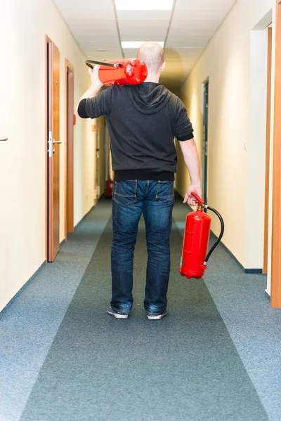 Hombre sosteniendo dos extintores — Foto de Stock